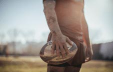 Homme tenant un ballon de rugby dans sa main